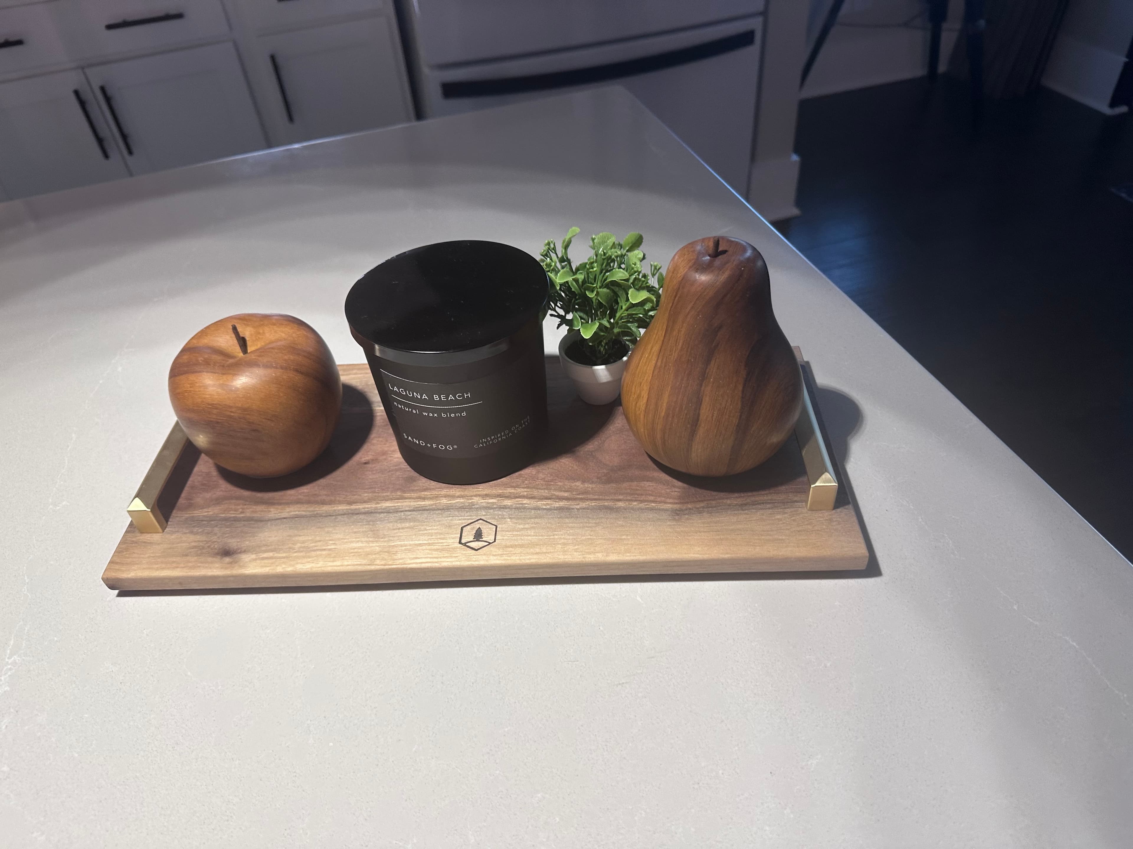 Styling detail — walnut tray with candle and natural decor